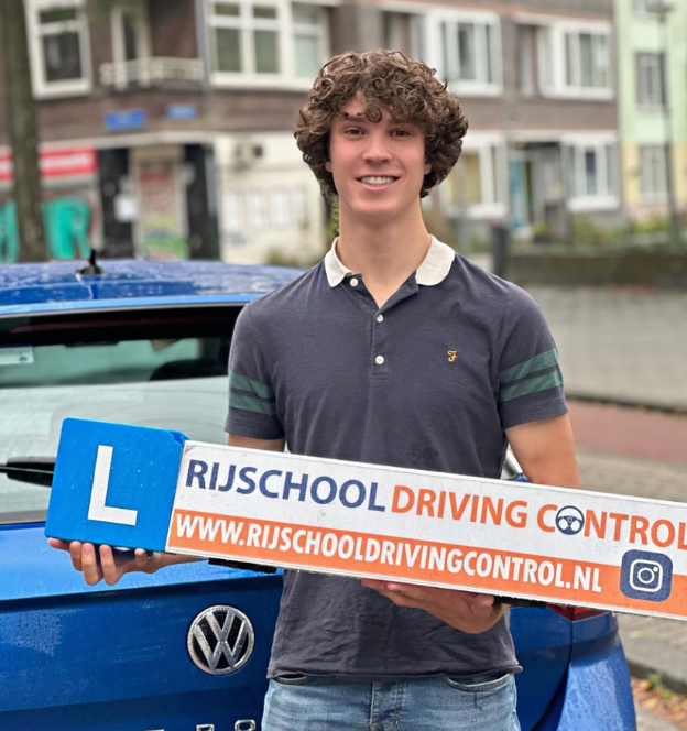 Blije leerling geslaagd bij Rijschool Rotterdam, staat naast een moderne lesauto met rijbewijs in de hand