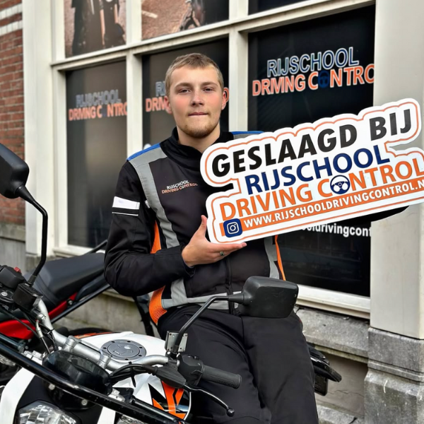 Nieuwe motorrijder viert behalen van motorrijbewijs bij rijschool in Schiedam.