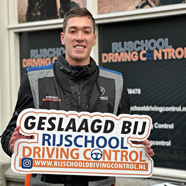 Geslaagde motorrijbewijs kandidaat straalt met certificaat in Schiedam.