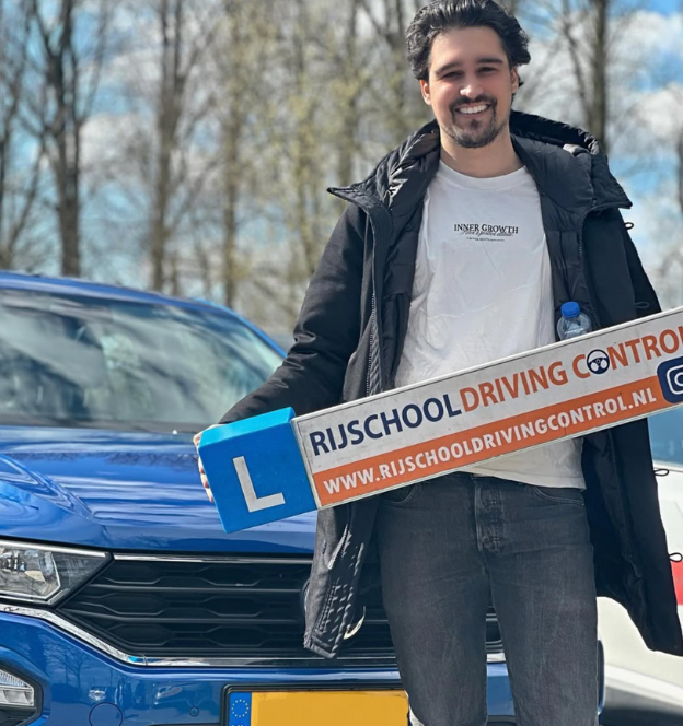 Geslaagde leerling met rijbewijs in de hand na het behalen van automaat rijexamen in Rotterdam
