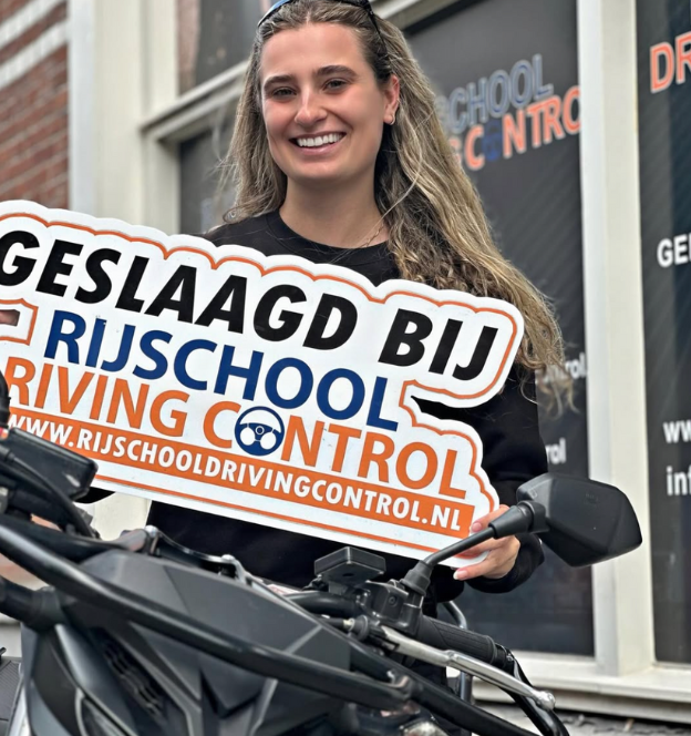 Blije geslaagde dame na het motor examen in Rotterdam met motorrijbewijs in de hand