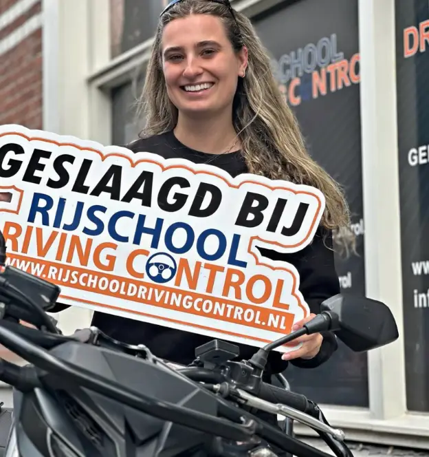 Blije geslaagde dame na het motor examen in Rotterdam met motorrijbewijs in de hand