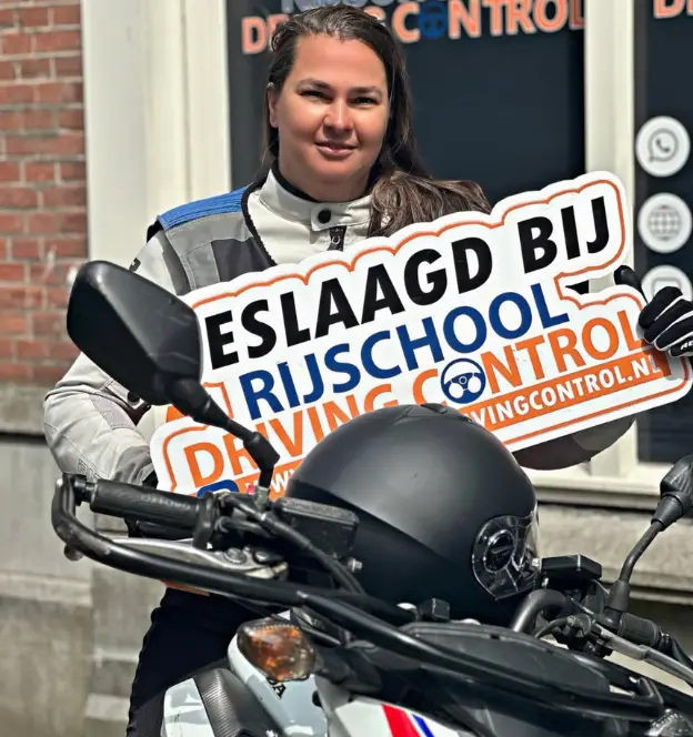 Blije leerling met motorrijbewijs na succesvol afronden van motorrijden Rotterdam routes