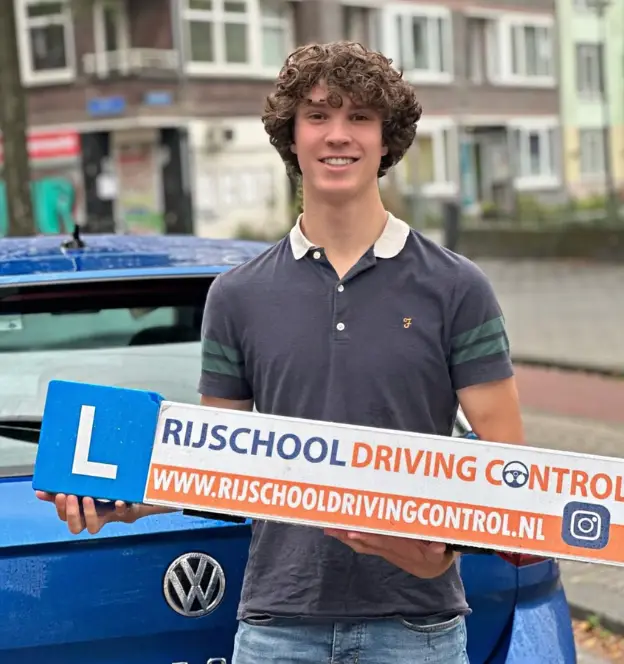 Rijbewijs gehaald in Maassluis – tevreden leerling poseert voor lesauto van Driving Control